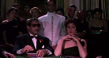 Movie still from “The Barefoot Contessa” (1954), directed by Joseph L. Mankiewicz – A group of people sitting around a table; Medium shot, Over the shoulder angle