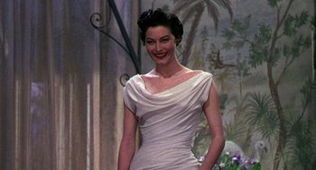 Movie still from “The Barefoot Contessa” (1954), directed by Joseph L. Mankiewicz – A woman in a white dress standing in front of a painting; Medium shot, Low angle