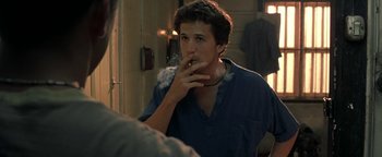 Movie still from “The Beach” (2000), directed by Danny Boyle – A man smoking a cigarette in front of a bathroom mirror; Close Up shot, Over the shoulder angle