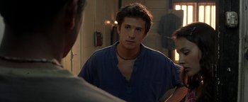 Movie still from “The Beach” (2000), directed by Danny Boyle – A young man looking into a mirror while wearing a necklace; Close Up shot, Over the shoulder angle