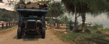 Movie still from “The Beach” (2000), directed by Danny Boyle – An old truck is driving down the street; Wide shot, Low angle