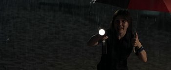 Movie still from “The Beach” (2000), directed by Danny Boyle – A woman holding a flashlight under an umbrella; Medium shot, Low angle