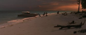 Movie still from “The Beach” (2000), directed by Danny Boyle – A group of people on a beach near a boat; Extreme Wide shot, High angle