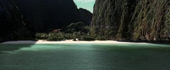 Movie still from “The Beach” (2000), directed by Danny Boyle – A view of a body of water with a mountain in the background; Extreme Wide shot, High angle