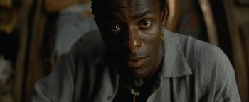 Movie still from “The Beach” (2000), directed by Danny Boyle – A person wearing a gray shirt; Close Up shot, High angle