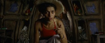 Movie still from “The Beach” (2000), directed by Danny Boyle – A woman wearing a straw hat and a red shirt; Close Up shot, Low angle