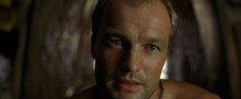 Movie still from “The Beach” (2000), directed by Danny Boyle – A man's face in a dark room; Close Up shot, Low angle