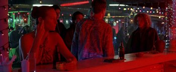 Movie still from “The Beach” (2000), directed by Danny Boyle – A group of young men standing around a bar; Medium shot, Over the shoulder angle