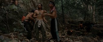 Movie still from “The Beach” (2000), directed by Danny Boyle – A group of people standing in the woods; Wide shot, High angle