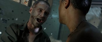 Movie still from “The Beach” (2000), directed by Danny Boyle – A man with a zombie makeup looking at another man with blood on his face; Close Up shot, Low angle