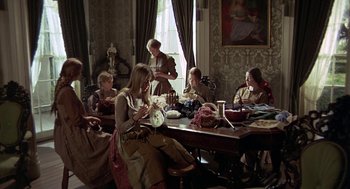 Movie still from “The Beguiled” (1971), directed by Don Siegel – A group of people sitting around a table; Wide shot, High angle