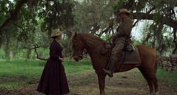Movie still from “The Beguiled” (1971), directed by Don Siegel – A man and a woman on a brown horse; Wide shot, Over the shoulder angle
