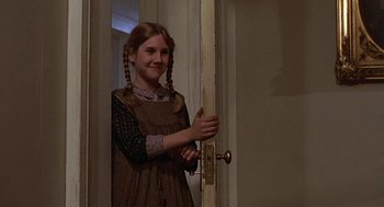 Movie still from “The Beguiled” (1971), directed by Don Siegel – A young girl with braids standing in front of an open door; Medium shot, Over the shoulder angle