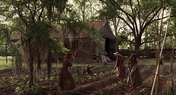 Movie still from “The Beguiled” (1971), directed by Don Siegel – A group of people working in a field with trees in the background; Extreme Wide shot, High angle