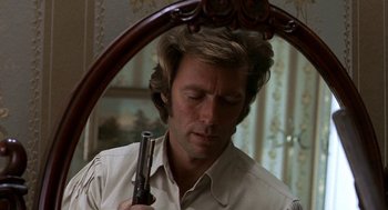 Movie still from “The Beguiled” (1971), directed by Don Siegel – A person holding a gun near a mirror; Close Up shot, Over the shoulder angle