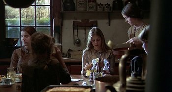 Movie still from “The Beguiled” (1971), directed by Don Siegel – A group of people sitting at a table in a room; Medium shot, Over the shoulder angle