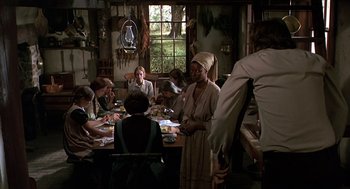Movie still from “The Beguiled” (1971), directed by Don Siegel – A group of people sitting around a table eating food; Wide shot, High angle