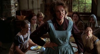 Movie still from “The Beguiled” (1971), directed by Don Siegel – A woman in an apron standing in front of a group of people; Medium shot, Low angle