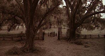 Movie still from “The Beguiled” (1971), directed by Don Siegel – A group of people standing under a large tree; Extreme Wide shot, High angle
