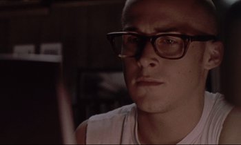 Movie still from “The Believer” (2001), directed by Henry Bean – A person wearing glasses and a white shirt; Close Up shot, Low angle