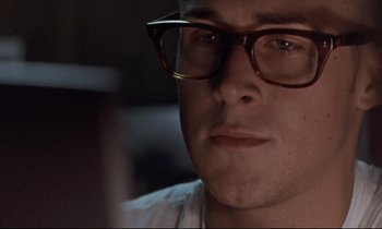 Movie still from “The Believer” (2001), directed by Henry Bean – A person wearing glasses; Close Up shot, Over the shoulder angle