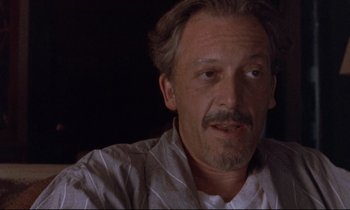 Movie still from “The Believer” (2001), directed by Henry Bean – A person with a beard and mustache; Close Up shot, Over the shoulder angle