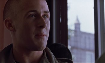 Movie still from “The Believer” (2001), directed by Henry Bean – A person looking at the camera; Close Up shot, Over the shoulder angle