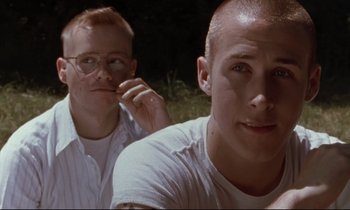 Movie still from “The Believer” (2001), directed by Henry Bean – Two men sitting next to each other in the grass; Close Up shot, Over the shoulder angle