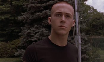 Movie still from “The Believer” (2001), directed by Henry Bean – A man in a black shirt is standing in front of a tree; Close Up shot, Low angle
