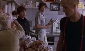 Movie still from “The Believer” (2001), directed by Henry Bean – A group of people standing in a kitchen; Medium shot, Over the shoulder angle