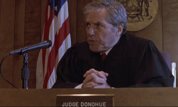 Movie still from “The Believer” (2001), directed by Henry Bean – A man in a court room with his hands clasped together; Close Up shot, High angle