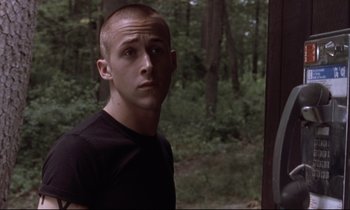 Movie still from “The Believer” (2001), directed by Henry Bean – A man with a shaved head standing in the woods; Close Up shot, Over the shoulder angle