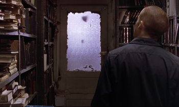 Movie still from “The Believer” (2001), directed by Henry Bean – A man standing in front of an open door; Medium shot, Over the shoulder angle