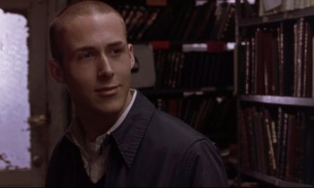 Movie still from “The Believer” (2001), directed by Henry Bean – A man in a jacket standing next to a bookshelf; Close Up shot, Over the shoulder angle