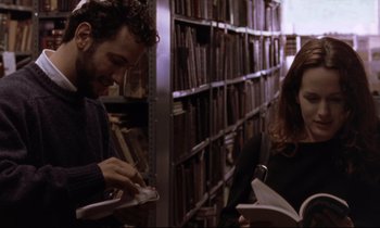 Movie still from “The Believer” (2001), directed by Henry Bean – A man and a woman in a library with books; Medium shot, Over the shoulder angle
