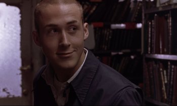 Movie still from “The Believer” (2001), directed by Henry Bean – A man with a shaved head is smiling for the camera; Close Up shot, Over the shoulder angle