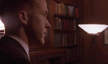 Movie still from “The Believer” (2001), directed by Henry Bean – A man in a suit is looking at a light; Close Up shot, Low angle