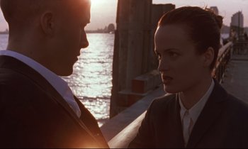 Movie still from “The Believer” (2001), directed by Henry Bean – A man and a woman standing next to each other near a body of water; Medium shot, Low angle