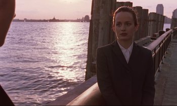 Movie still from “The Believer” (2001), directed by Henry Bean – A woman in a suit standing next to a body of water; Medium shot, Over the shoulder angle