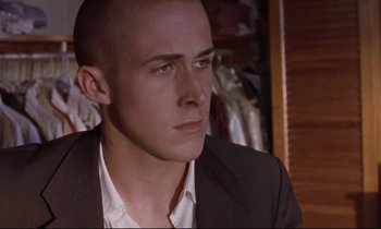 Movie still from “The Believer” (2001), directed by Henry Bean – A man in a suit and tie looking to his left; Close Up shot, Over the shoulder angle