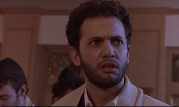 Movie still from “The Believer” (2001), directed by Henry Bean – A person wearing a suit and tie; Close Up shot, Low angle