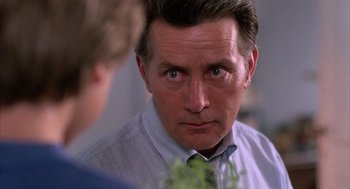 Movie still from “The Believers” (1987), directed by John Schlesinger – A person wearing a shirt and a tie; Close Up shot, Over the shoulder angle