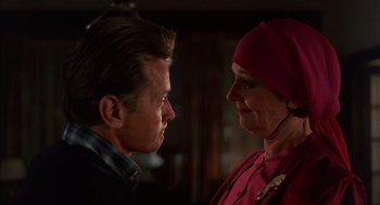 Movie still from “The Believers” (1987), directed by John Schlesinger – A man and a woman face to face in front of a mirror; Close Up shot, Over the shoulder angle