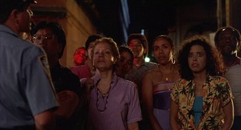 Movie still from “The Believers” (1987), directed by John Schlesinger – A group of people standing in the street at night; Medium shot, Low angle