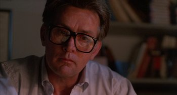Movie still from “The Believers” (1987), directed by John Schlesinger – A person wearing glasses and a white shirt; Close Up shot, Low angle