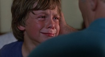 Movie still from “The Believers” (1987), directed by John Schlesinger – A young boy crying in front of an adult; Close Up shot, Over the shoulder angle