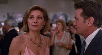 Movie still from “The Believers” (1987), directed by John Schlesinger – A woman in a pink dress looking at a man in a pink dress; Close Up shot, Over the shoulder angle
