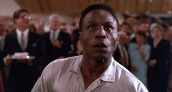 Movie still from “The Believers” (1987), directed by John Schlesinger – A person wearing a white shirt; Close Up shot, Low angle