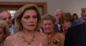 Movie still from “The Believers” (1987), directed by John Schlesinger – A group of people standing in a room; Close Up shot, Over the shoulder angle