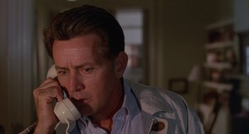 Movie still from “The Believers” (1987), directed by John Schlesinger – A person talking on a phone; Close Up shot, Low angle